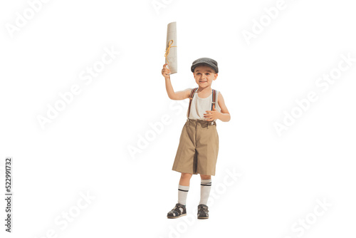 Cute happy kid in retro style shorts holding newspaper isolated on white studio background. Retro vintage style concept. Friendship, hobbies, art photo