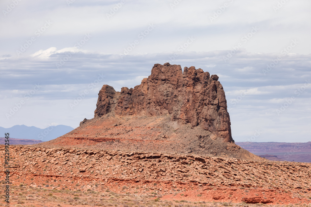 Fototapeta premium Red Rock Mountain Landscape during sunny and cloudy day. Alhambra Rock near Mexican Hat, Utah, United States. American Nature Background