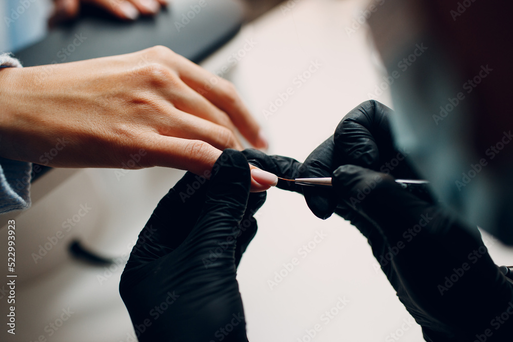 Manicure process female hands finger nails polish at nail salon