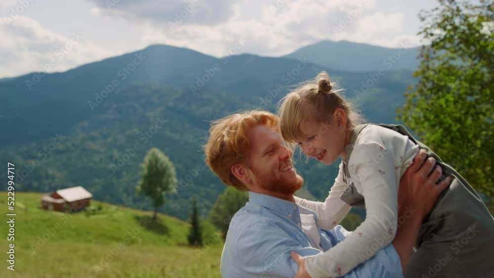 Father picking up daughter on mountain valley close up. Man circling cute girl. Father picking up daughter on mountain valley close up. Man circling cute girl.