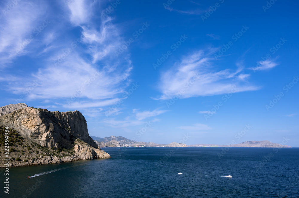 Scenic landscape of blue sea, cloudy sky. Huge rocks. Beautiful nature.