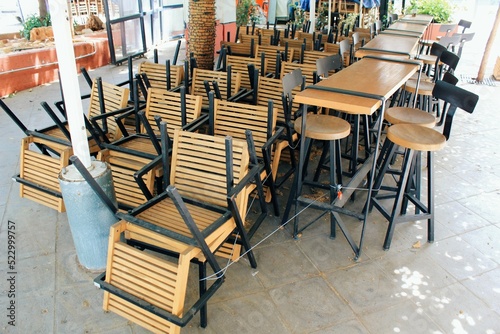 Tables and chairs stacked outside closed cafe-restaurant during the Coronavirus lockdown - Athens, Greece, May 6 2020.