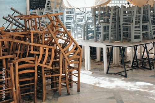 Tables and chairs stacked outside closed cafe-restaurant during the Coronavirus lockdown - Athens, Greece, May 6 2020.