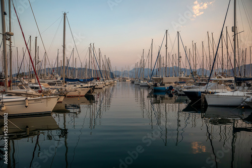 White yachts are in the bay at sunset. Calm sea. Mountains in the background. Beautiful evening in Marmaris. © Kooper