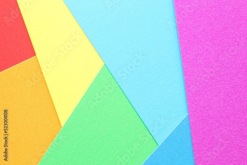 Abstract creative textured geometric pattern from craft paper background. Rainbow colors. Structure design cardboard poster shape backdrop. Top view with copy space for text, flat lay, close-up
