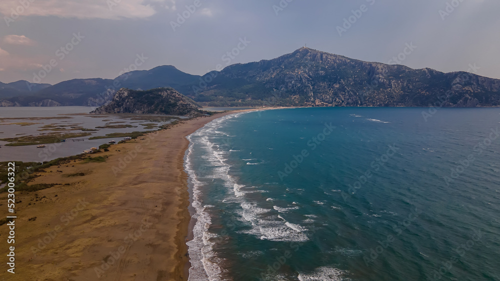 Long sandy beach. Sand braid. Sea and river. The mountains. Strong waves on the sea. Clouds in the sky. Beautiful nature. Long sandy beach. Sand braid. Sea and river. The mountains. Strong waves on the sea. Clouds in the sky. Beautiful nature.