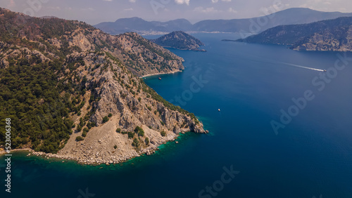 Beautiful seashore. Islands in the distance. Colorful blue sea. The beauty of Turkey. Beautiful rocks and mountains. Sunny clear day. Beautiful water. © Kooper