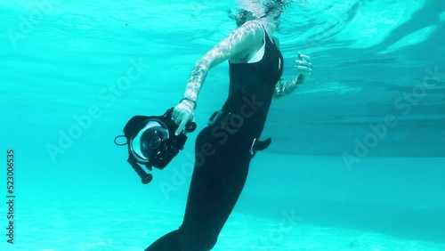 Shiver Of Blacktip Sharks Swimming By Female Scuba Diver - Bimini, The Bahamas photo