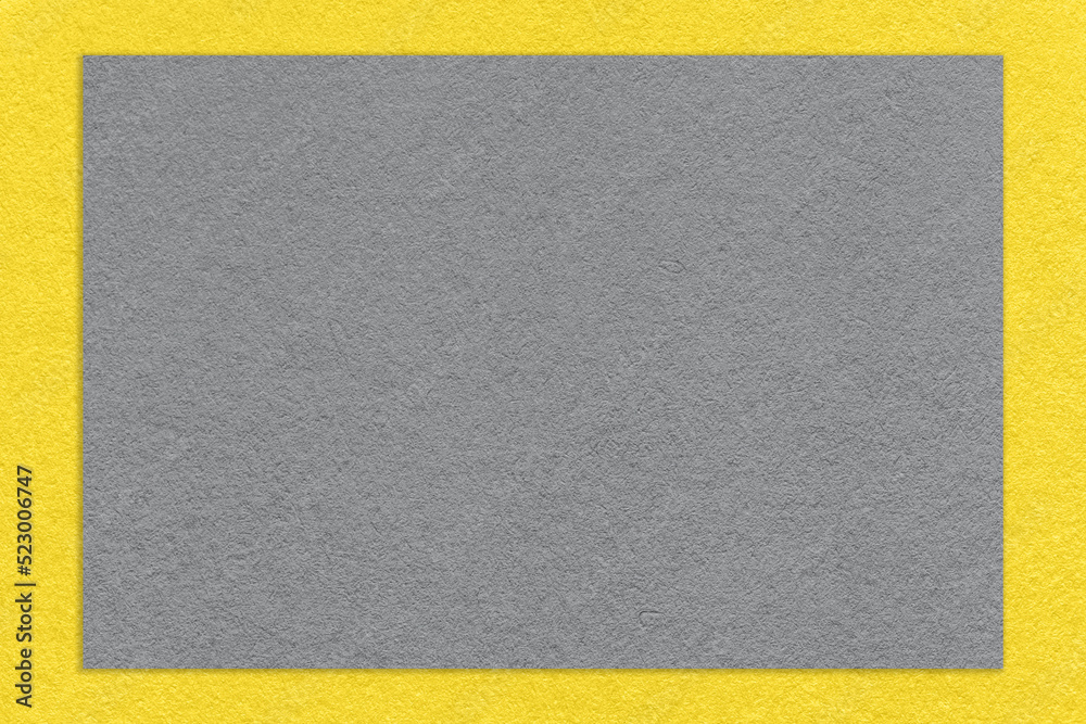 Texture of craft gray color paper background with yellow border, macro. Structure of vintage grey cardboard