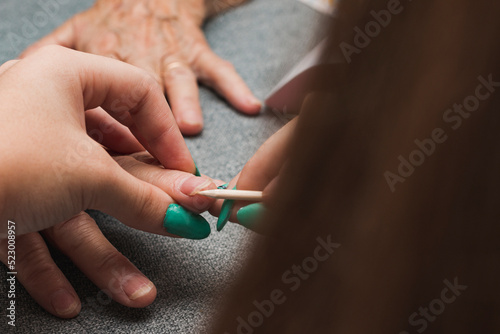 Young girl cleaning older woman s nails