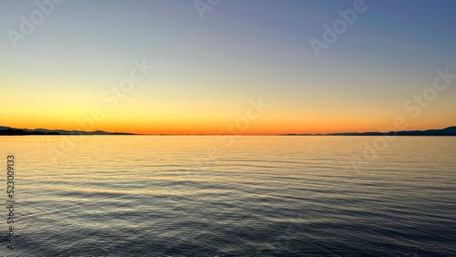 sunset on Ocean Calmness and silence is like a lake or sea on resting in trailers on the shore bright colors of dark blue orange stripe on the horizon from sun rich space for text travel advertising