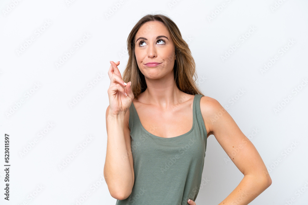 Fototapeta premium Young caucasian woman isolated on white background with fingers crossing and wishing the best
