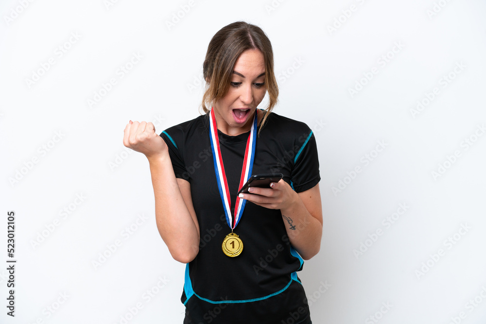 Young caucasian woman with medals isolated on white background surprised and sending a message Young caucasian woman with medals isolated on white background surprised and sending a message
