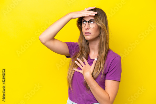 Young caucasian woman isolated on yellow background With glasses and tired