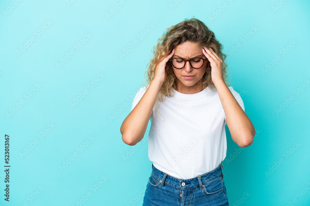 Girl with curly hair isolated on blue background with headache Girl with curly hair isolated on blue background with headache