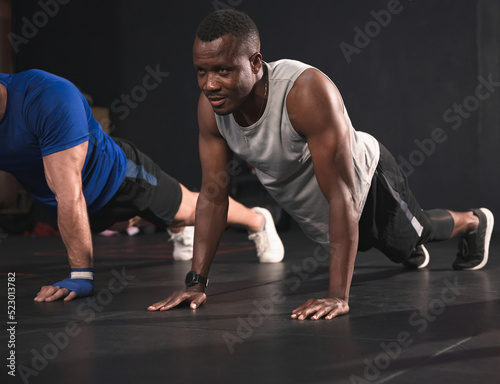 African American sport man push ups at fitness gym 