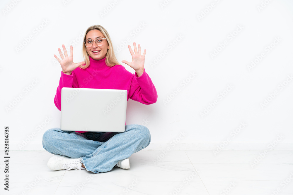 Young caucasian woman with laptop sitting on the floor counting ten with fingers Young caucasian woman with laptop sitting on the floor counting ten with fingers