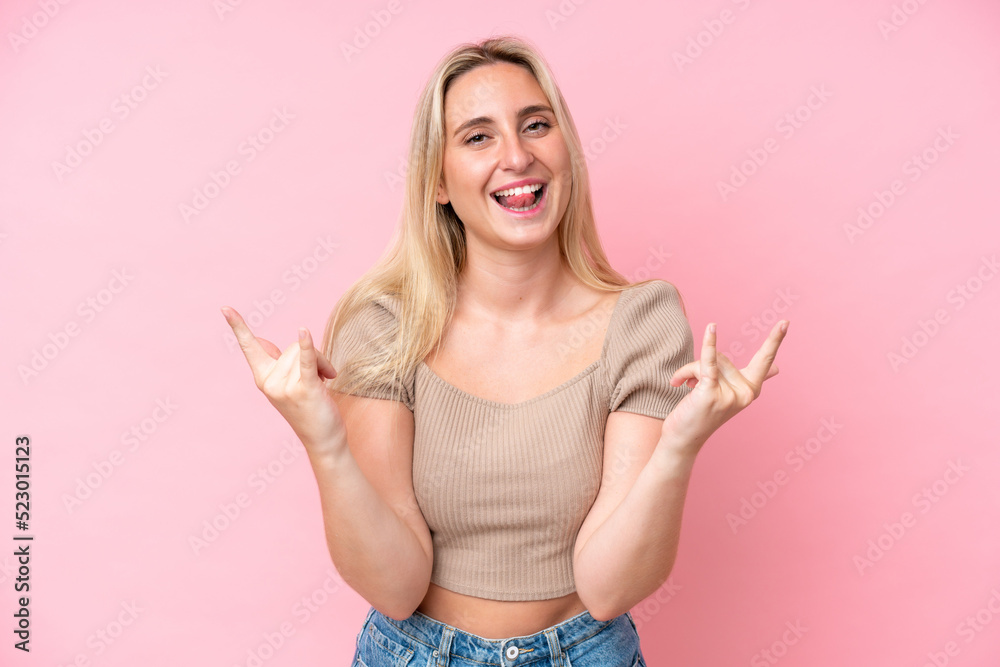 Young caucasian woman isolated on pink background making horn gesture Young caucasian woman isolated on pink background making horn gesture