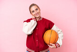Young basketball caucasian player woman isolated on pink background laughing