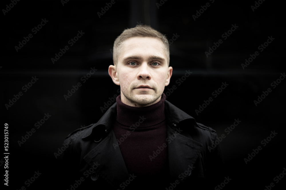 Ukrainian man in black trenchcoat and purple polo Ukrainian man in black trenchcoat and purple polo
