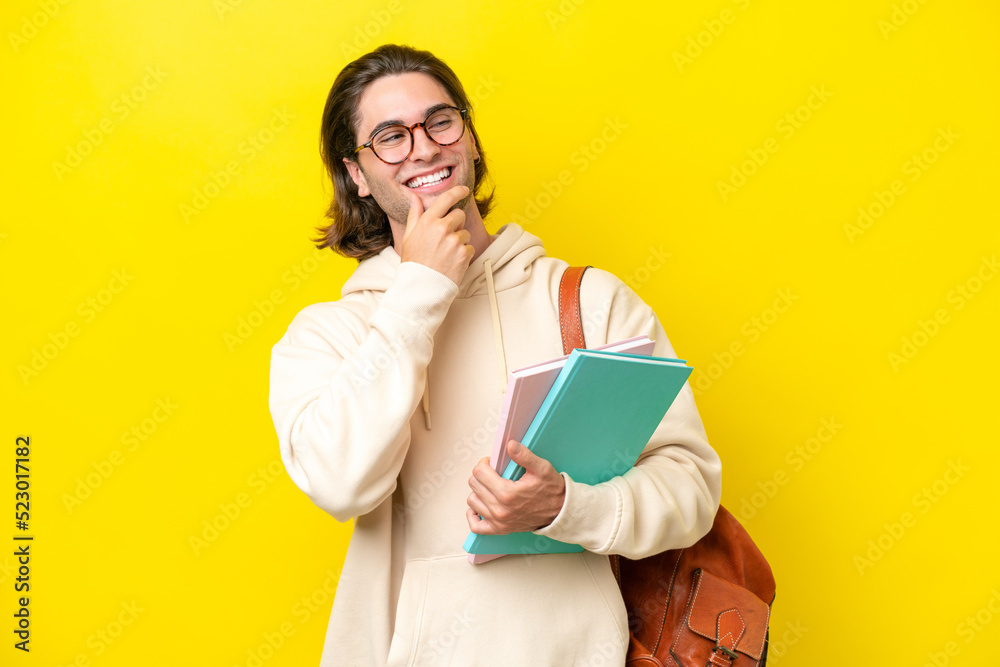 Young student handsome man isolated on yellow background looking to the side and smiling Young student handsome man isolated on yellow background looking to the side and smiling
