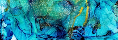 Golden dust on blue and green Alcohol ink fluid abstract texture fluid art with gold glitter and liquid.