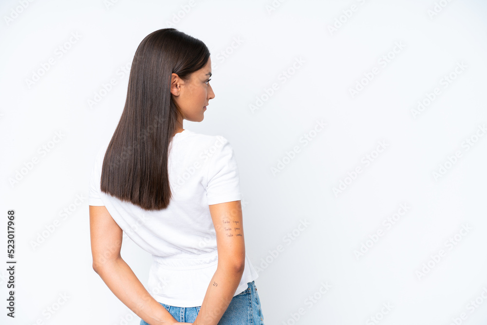Young caucasian woman isolated on white background in back position and looking back Young caucasian woman isolated on white background in back position and looking back