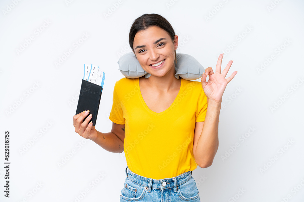 Woman with Inflatable Travel Pillow over isolated background showing ok sign with fingers Woman with Inflatable Travel Pillow over isolated background showing ok sign with fingers