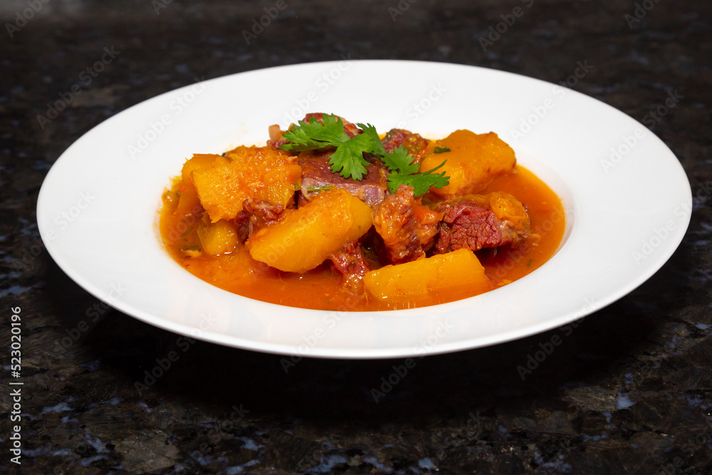 Dry meat with pumpkin, traditional Brazilian rustic dish. Black background