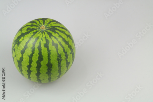 Whole watermelon on gray background with space for text. 