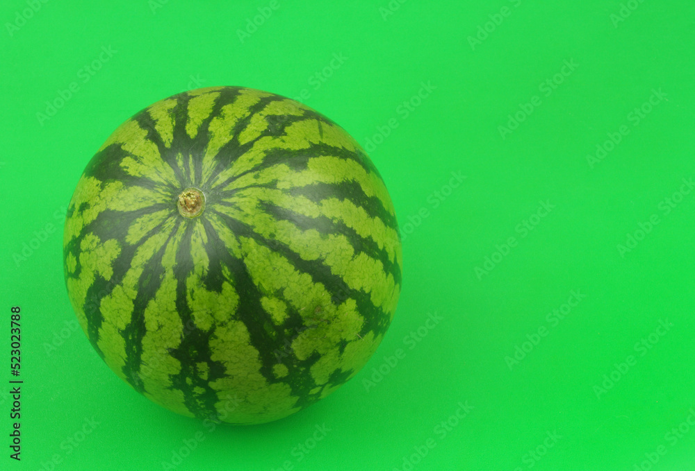 Whole watermelon on green background with room for text. Whole watermelon on green background with room for text.
