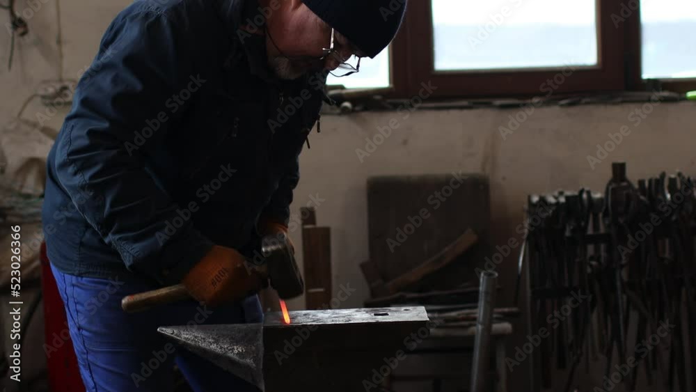 Blacksmith forges and making arrow arrowhead metal detail with hammer and anvil at forge. Blacksmith forges and making arrow arrowhead metal detail with hammer and anvil at forge.