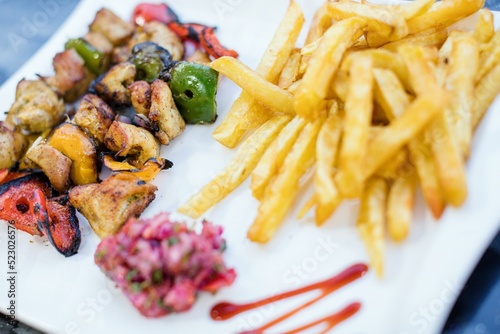 Fried potatoes and fish with vegetables