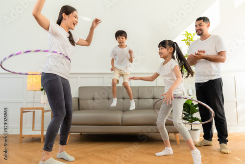Young asian parents with child meditating at home isolated in room. Family, sport, yoga concept.