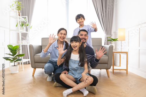 Portrait of asian family mother father and kids at home on sofa in living room.happy family concept.