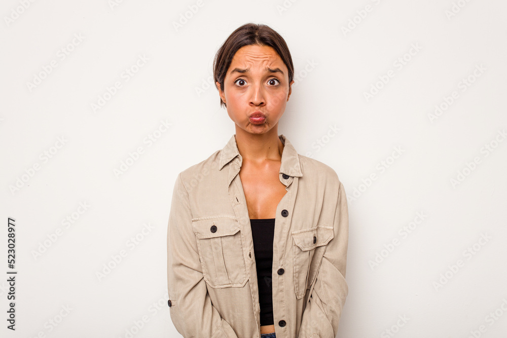 Young hispanic woman isolated on white background blows cheeks, has tired expression. Facial expression concept. Young hispanic woman isolated on white background blows cheeks, has tired expression. Facial expression concept.
