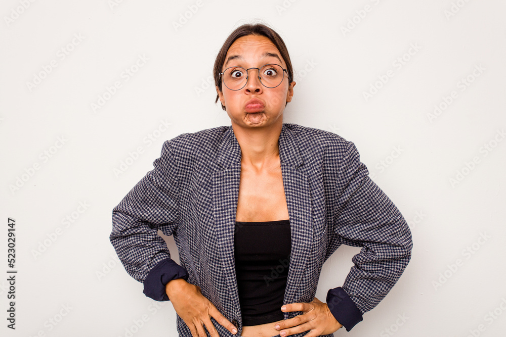 Young hispanic woman isolated on white background blows cheeks, has tired expression. Facial expression concept. Young hispanic woman isolated on white background blows cheeks, has tired expression. Facial expression concept.