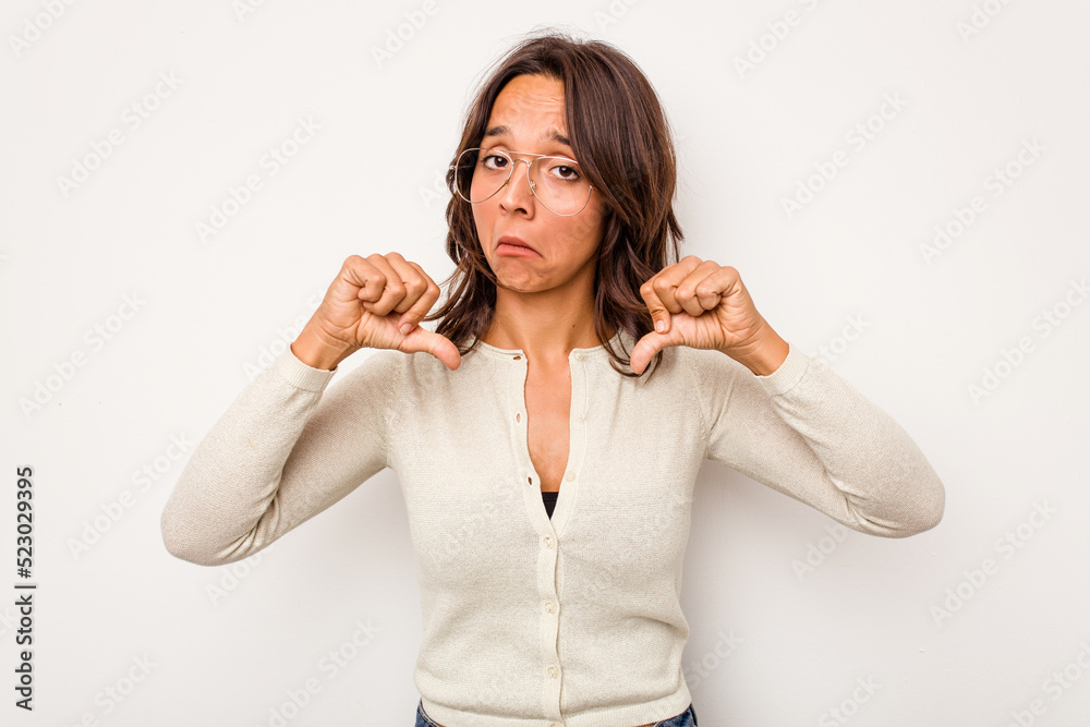 Young hispanic woman isolated on white background showing thumb down, disappointment concept. Young hispanic woman isolated on white background showing thumb down, disappointment concept.