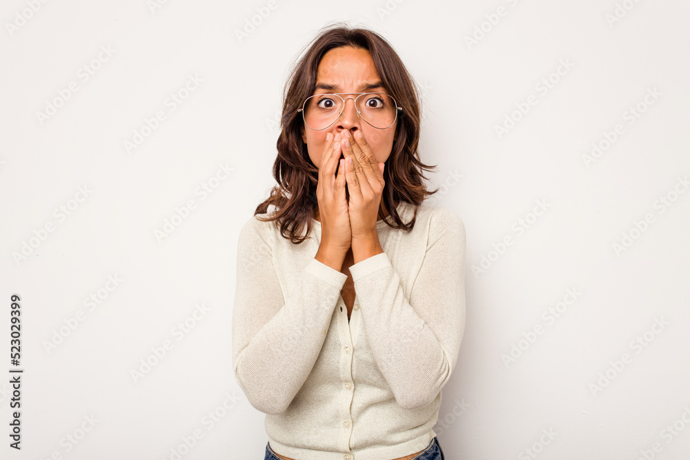 Young hispanic woman isolated on white background covering mouth with hands looking worried. Young hispanic woman isolated on white background covering mouth with hands looking worried.