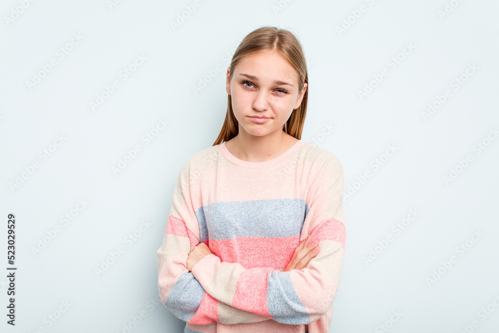Young caucasian girl isolated on blue background frowning face in displeasure, keeps arms folded. Young caucasian girl isolated on blue background frowning face in displeasure, keeps arms folded.