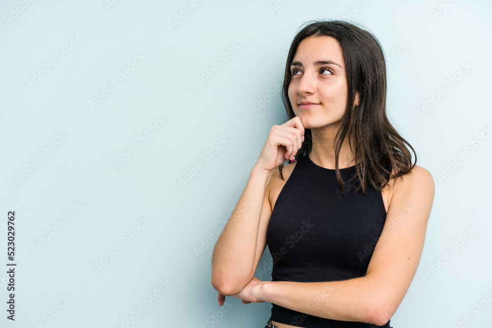 Young caucasian woman isolated on blue background looking sideways with doubtful and skeptical expression. Young caucasian woman isolated on blue background looking sideways with doubtful and skeptical expression.