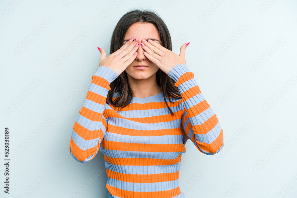 Young caucasian woman isolated on blue background afraid covering eyes with hands. Young caucasian woman isolated on blue background afraid covering eyes with hands.