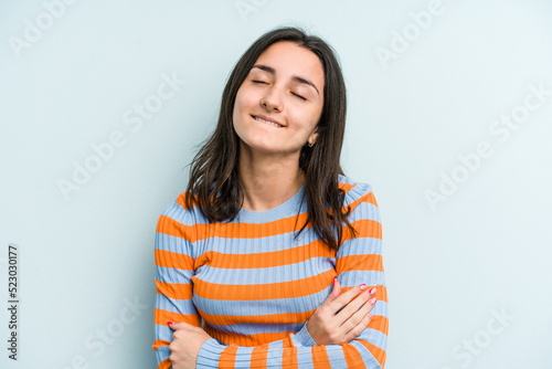 Young caucasian woman isolated on blue background laughing and having fun.