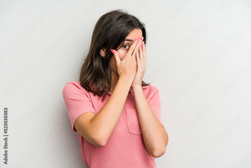 Young caucasian woman isolated on white background blink through fingers frightened and nervous. Young caucasian woman isolated on white background blink through fingers frightened and nervous.