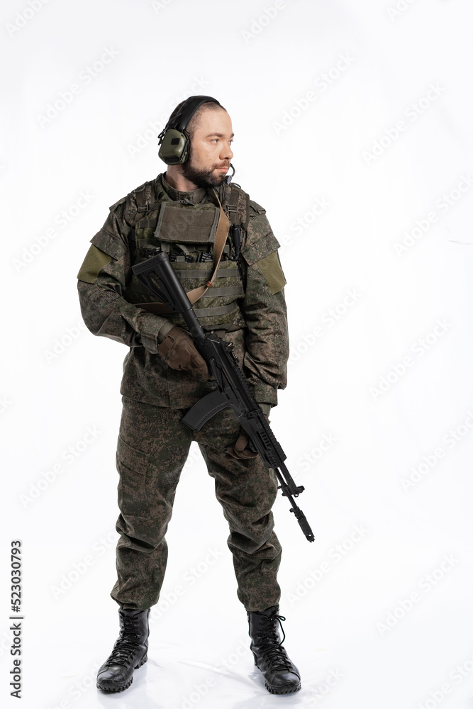 soldier in the studio on a white background. a man in military uniform with a rifle or machine gun. military or airball player soldier in the studio on a white background. a man in military uniform with a rifle or machine gun. military or airball player