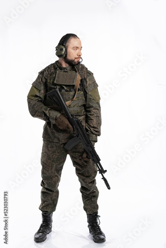 soldier in the studio on a white background. a man in military uniform with a rifle or machine gun. military or airball player