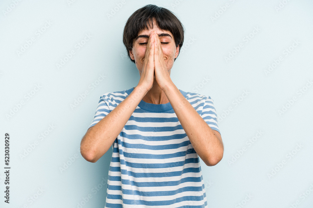 Young caucasian woman with a short hair cut isolated holding hands in pray near mouth, feels confident. Young caucasian woman with a short hair cut isolated holding hands in pray near mouth, feels confident.