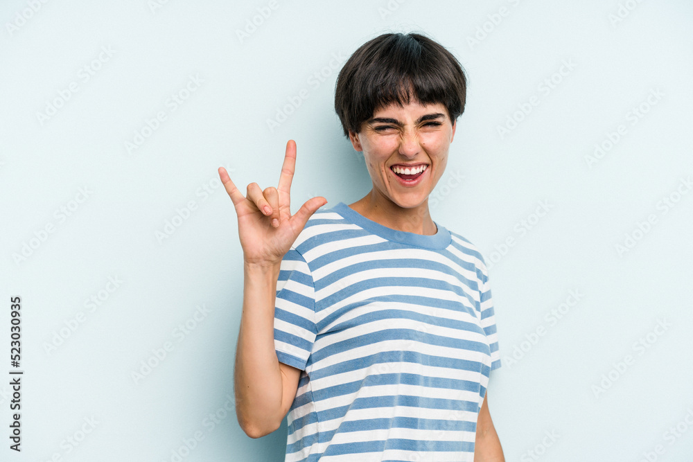 Young caucasian woman with a short hair cut isolated showing a horns gesture as a revolution concept. Young caucasian woman with a short hair cut isolated showing a horns gesture as a revolution concept.