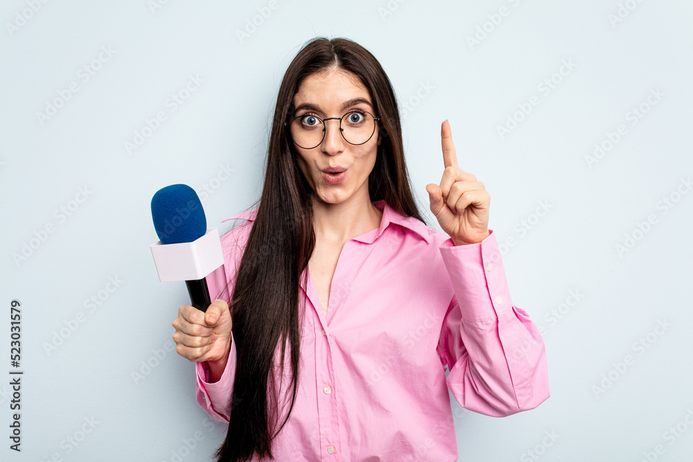 Young caucasian tv presenter woman isolated on blue background having some great idea, concept of creativity. Young caucasian tv presenter woman isolated on blue background having some great idea, concept of creativity.