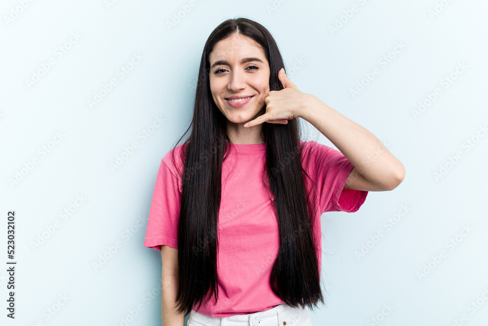 Young caucasian woman isolated on blue background showing a mobile phone call gesture with fingers. Young caucasian woman isolated on blue background showing a mobile phone call gesture with fingers.